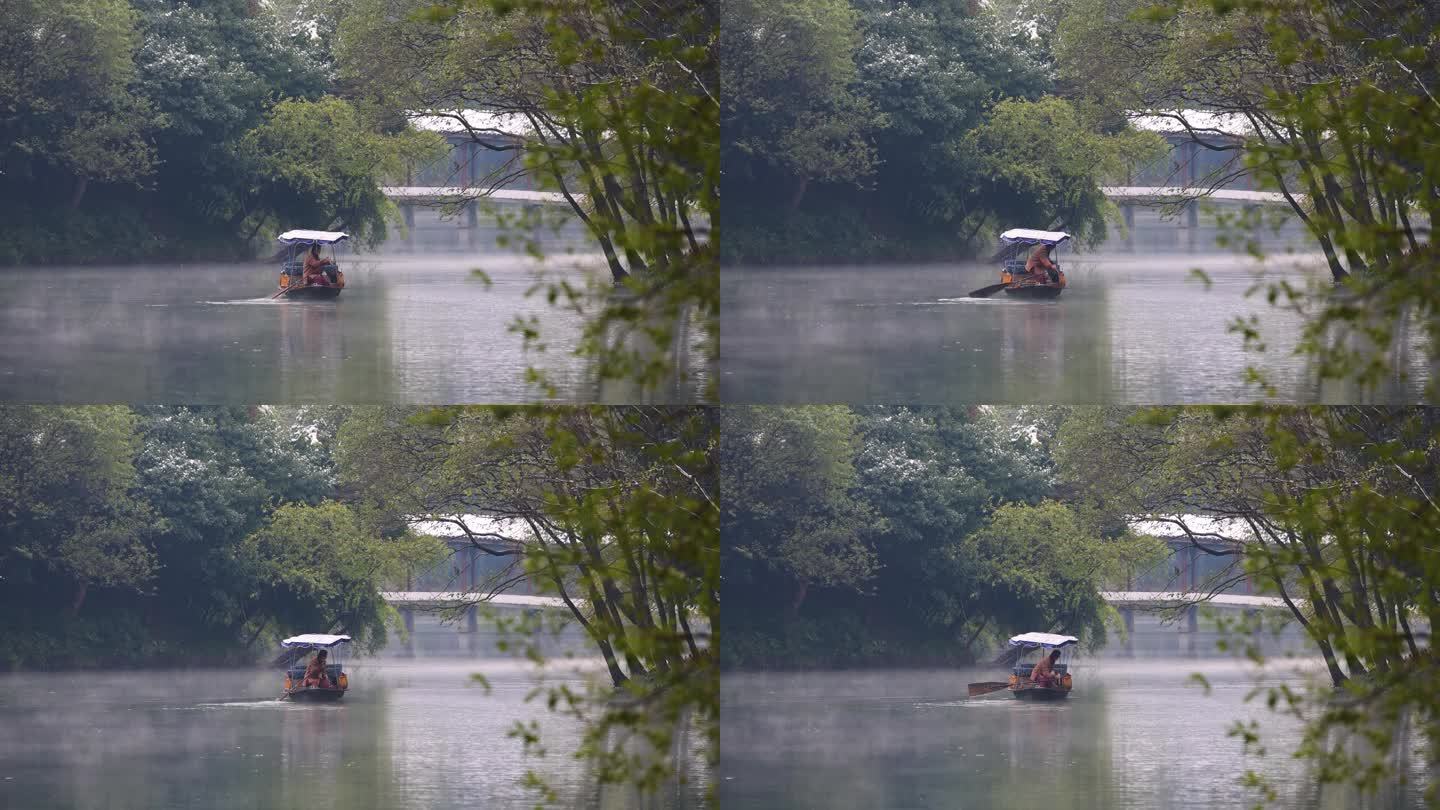 西湖湿地晨雾中的手划船