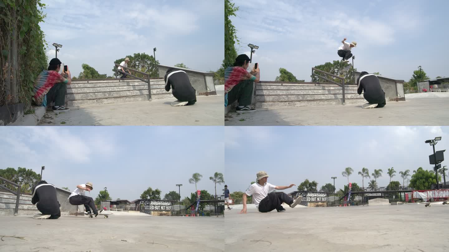 慢镜头拍摄的是一名亚洲男子在滑板公园白天为朋友滑下楼梯拍照