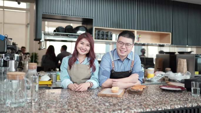亚洲中国企业主面带微笑，带着围裙准备重新开放咖啡馆业务。