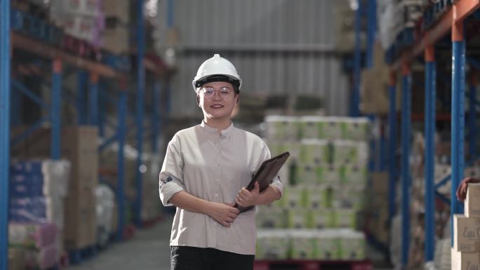 亚洲中国熟女戴着安全帽在仓库里微笑着看着镜头