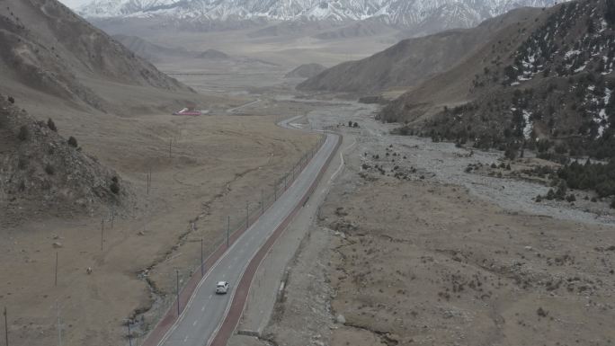 4K航拍 汽车行驶在新疆巍峨雪山