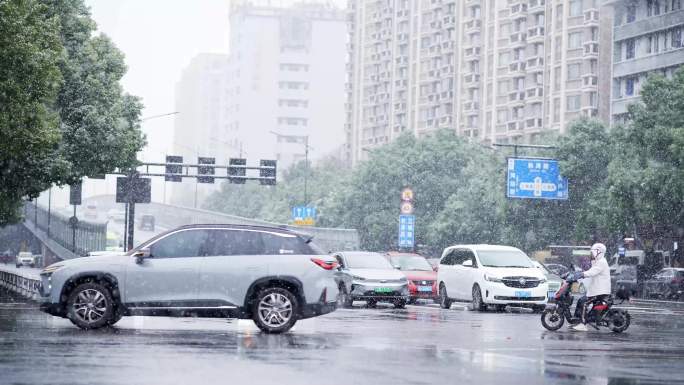 杭州冬天下雪天街头车辆和行人