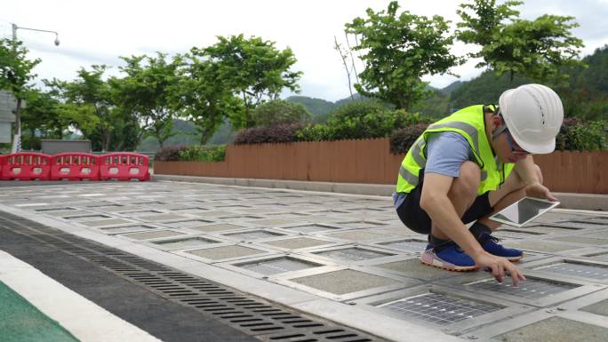 年轻的技术人员检查安装在路上的太阳能电池板