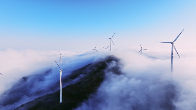 蓝色天空下云雾中高山上的风力发电机组
