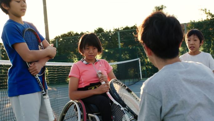 SLO MO拍摄了一名教练与一队青少年适应性网球运动员交谈的广角镜头