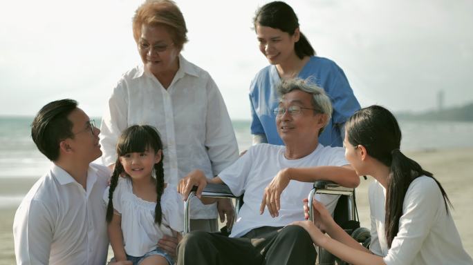 欢乐的亚洲大家庭在沙滩上享受日落的海浪。家庭，生活方式，人，人寿保险，多代人，老年人，假期，关系，儿