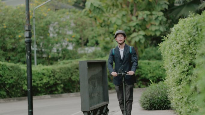 可持续的商业生活方式生活在城市里，骑着电动推板车上班。