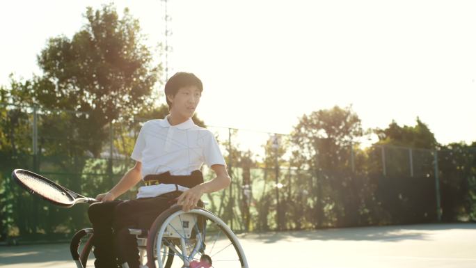 SLO MO坐在轮椅上打网球的十几岁男孩的中景