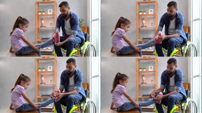 坐在轮椅上的父亲把运动鞋放在女儿的脚上