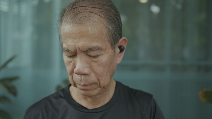 一位戴着蓝牙耳机的亚洲老人。