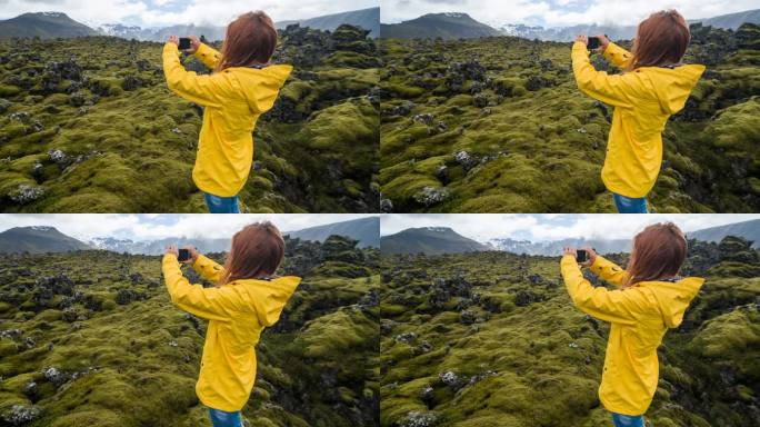 穿着黄色雨衣的游客在冰岛火山景观上拍摄苔藓覆盖物