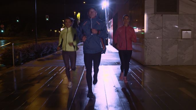 TS男子和两名女子晚上在城市里跑步