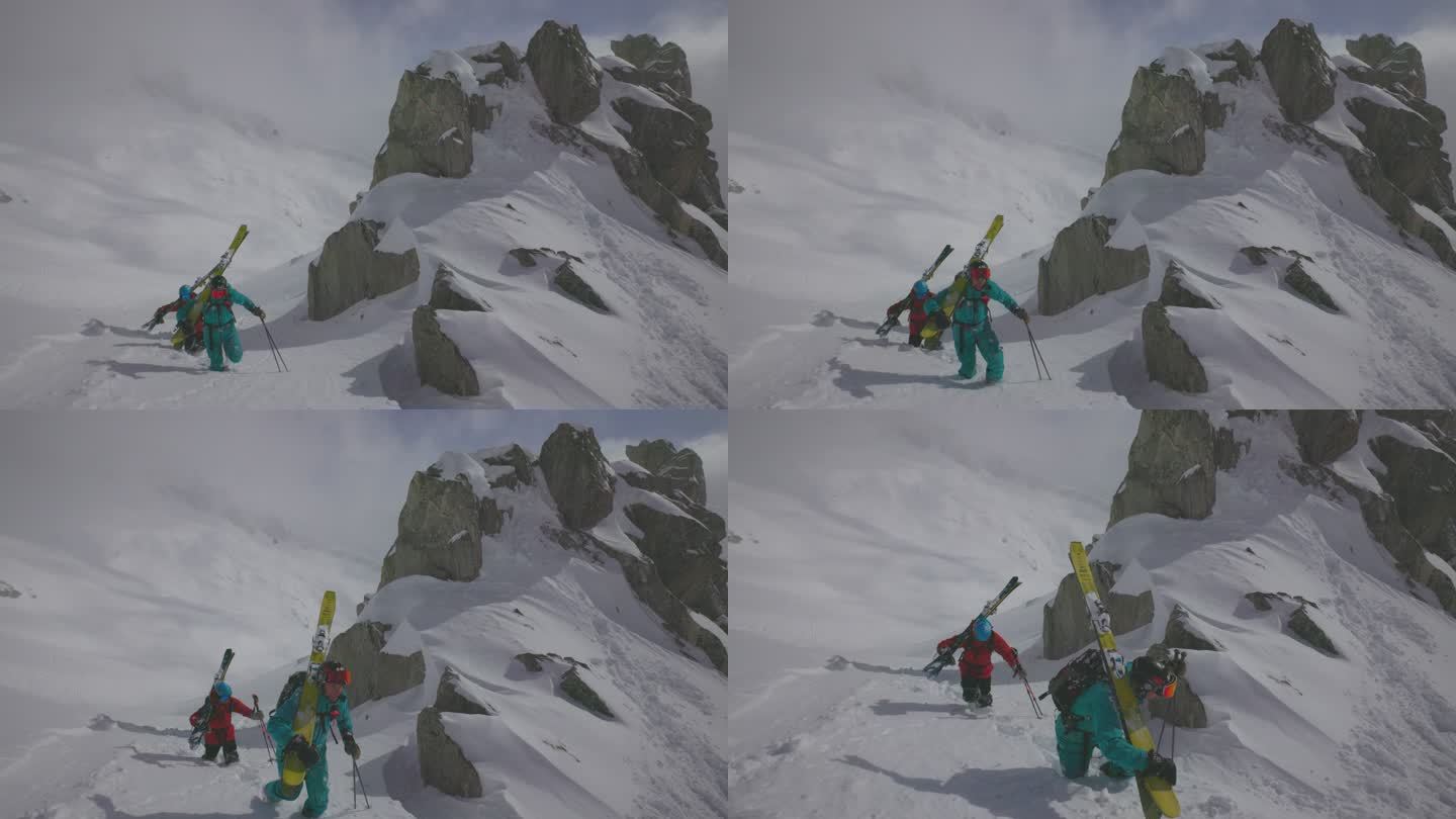 两名滑雪者背着滑雪板攀登山坡
