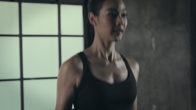 女运动员在室内健身房使用跳绳。