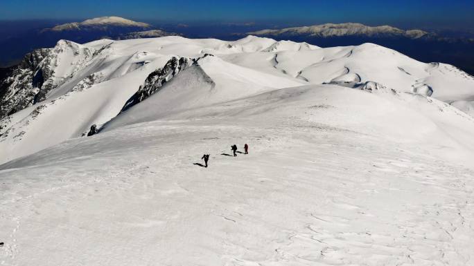 冬季，成功登山队在高海拔雪山顶峰的山脊上连续攀登，无人机鸟瞰图