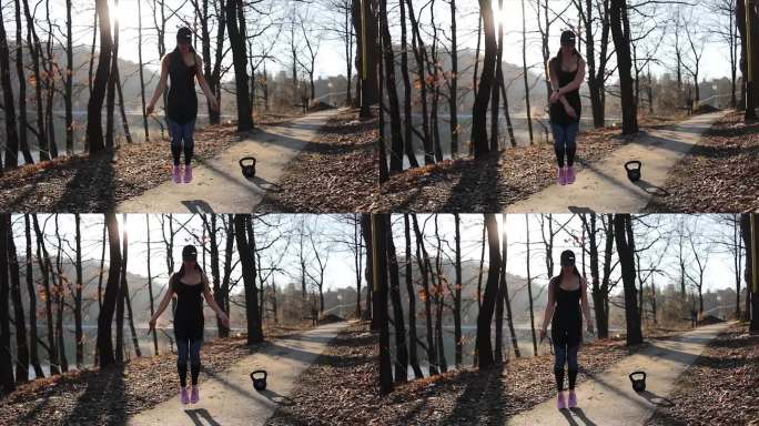 年轻女子跳绳。在春季公园用跳绳进行户外运动的女运动员