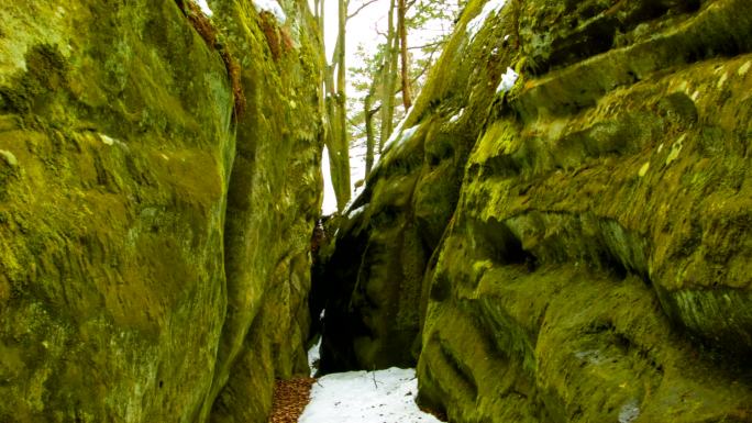 山上的绿色岩石。山林潮湿冬天大雪覆盖苔藓