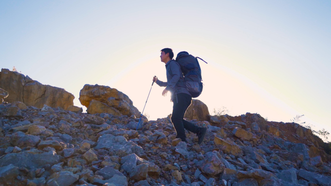 背包客户外探险走过碎石山顶攀登顶峰旅行者