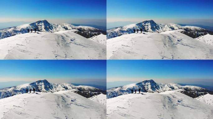 冬季成功登山队在高海拔雪山山顶张开双臂的无人机鸟瞰图