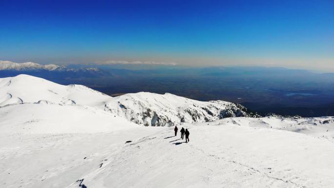 冬季，成功登山队在高海拔雪山顶峰的山脊上连续攀登，无人机鸟瞰图
