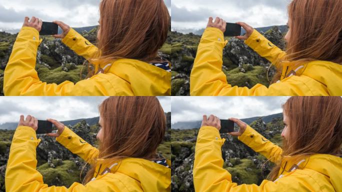 一位妇女在刮风的日子里拍摄冰岛的岩石和苔藓景观
