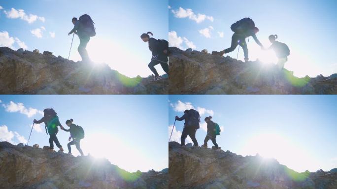团队登山手拉手爬上山顶成功登顶攀登顶峰