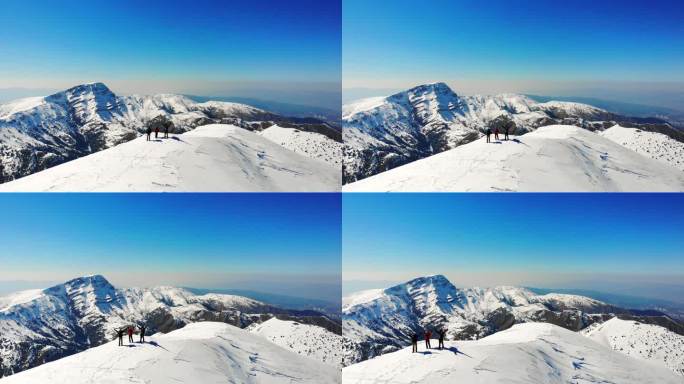 冬季成功登山队在高海拔雪山山顶张开双臂的无人机鸟瞰图