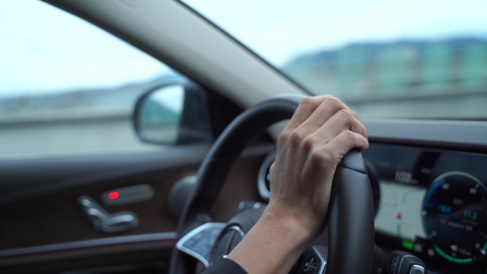 开车驾驶员手握方向盘特写仪表盘汽车行驶