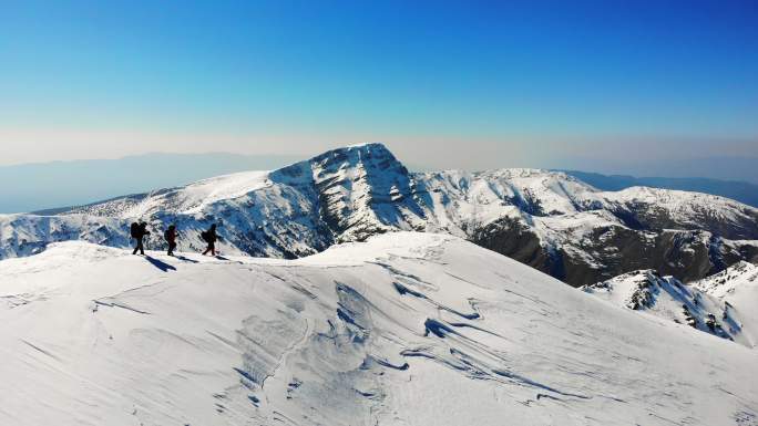 冬季，成功登山队在高海拔雪山顶峰的山脊上连续攀登，无人机鸟瞰图