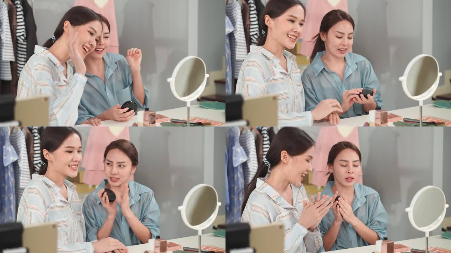 两个年轻漂亮的亚洲女孩正在为在线销售化妆品进行视频录制。亚洲女性化妆师在服装和化妆品店向网上顾客推荐