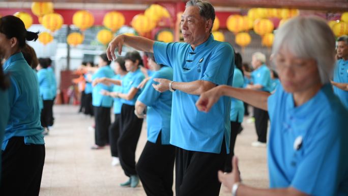 老人在寺庙里集体练习太极