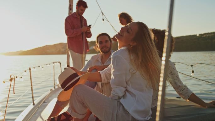 日落时分，一群年轻人在船的甲板上玩得很开心