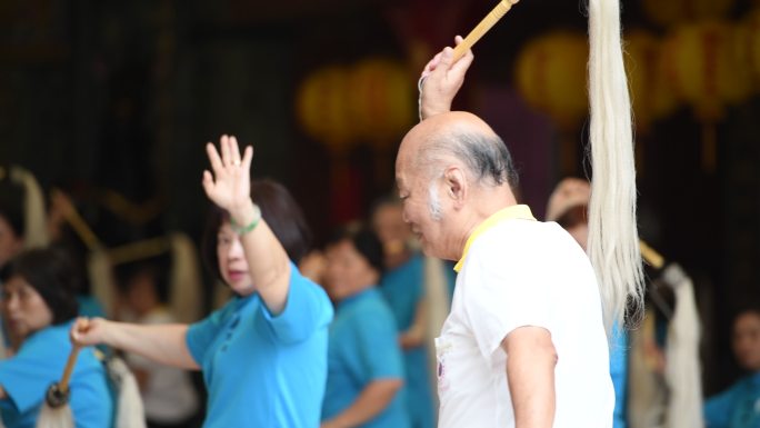 老年人在寺庙里一起打太极拳