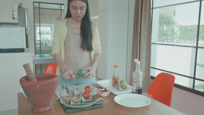 女人准备泰国菜的辣木瓜沙拉。“SOM TAM”