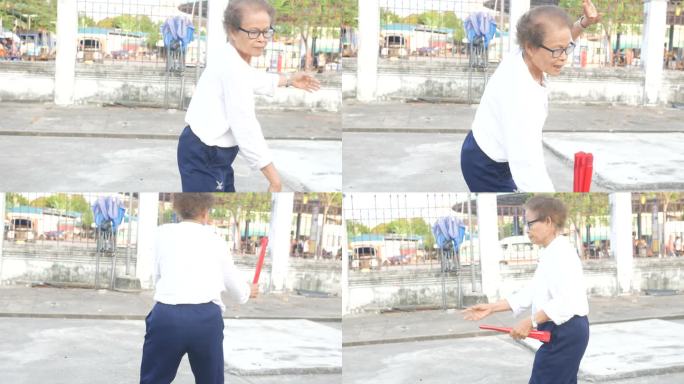 老年妇女在停车场练习中国手扇舞