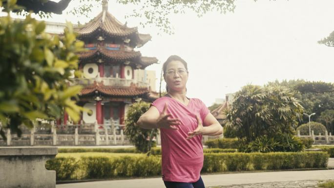 活跃的亚洲女学长在公园里打太极