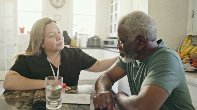 护理人员在上门拜访时与迈阿密黑人老年人交谈
