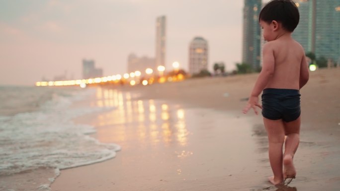 慢动作：亚洲男婴在海滩上玩耍