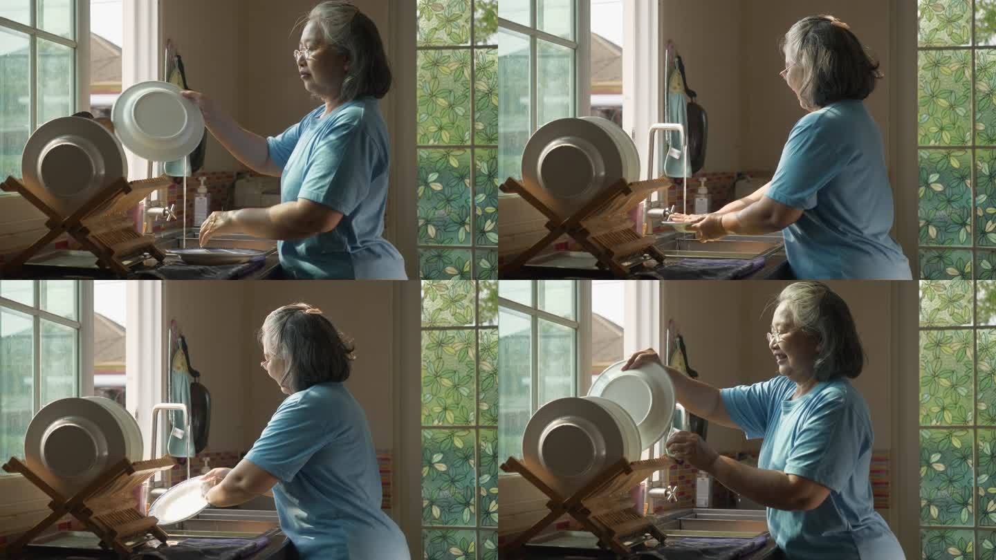老年人健康生活理念。老年妇女晚上在家里的厨房里洗碗。