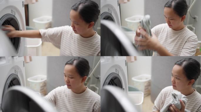 亚洲妇女在白天把衣服装进洗衣机做日常家务