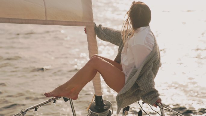 SLO MO年轻女子在帆船船头享受微风