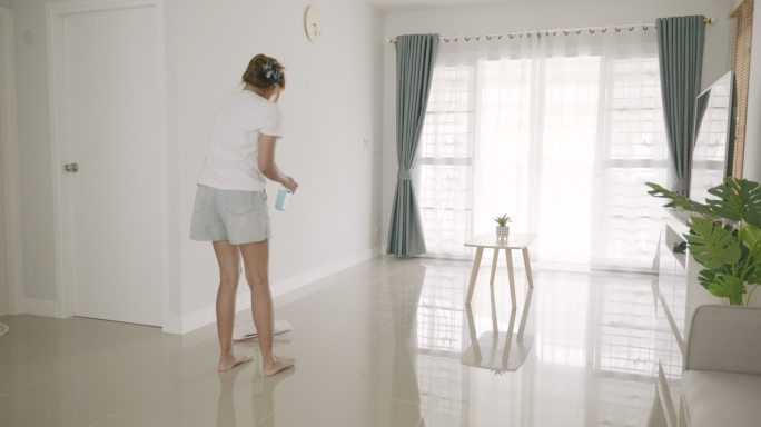 亚洲女人打扫新买的房子的场景。