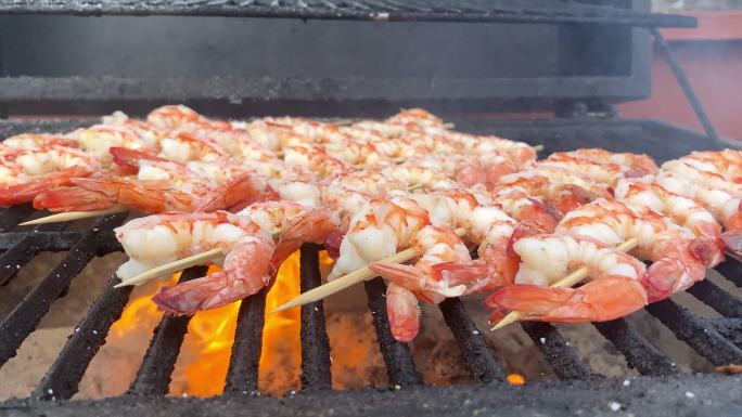 烤架上的烤串巨型虾配调味料