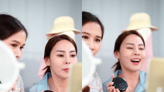 两位亚洲女性博客写手正在家里用相机评论她们的扑面粉产品。美丽的美妆博主Influencer女孩正在直