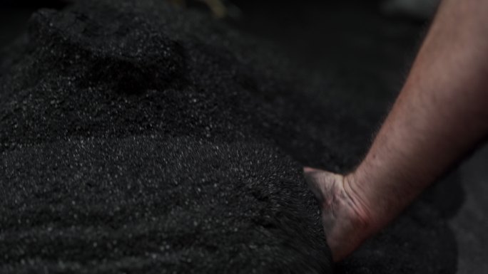 男人握着黑煤的手矿山开采隧道工作人员