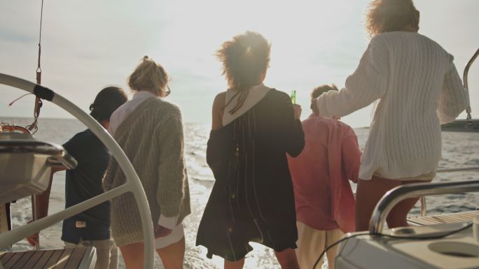 日落时分，一群年轻人在船的甲板上举行聚会