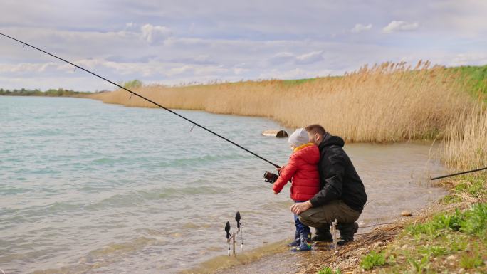 父亲和儿子在河上摇鱼竿