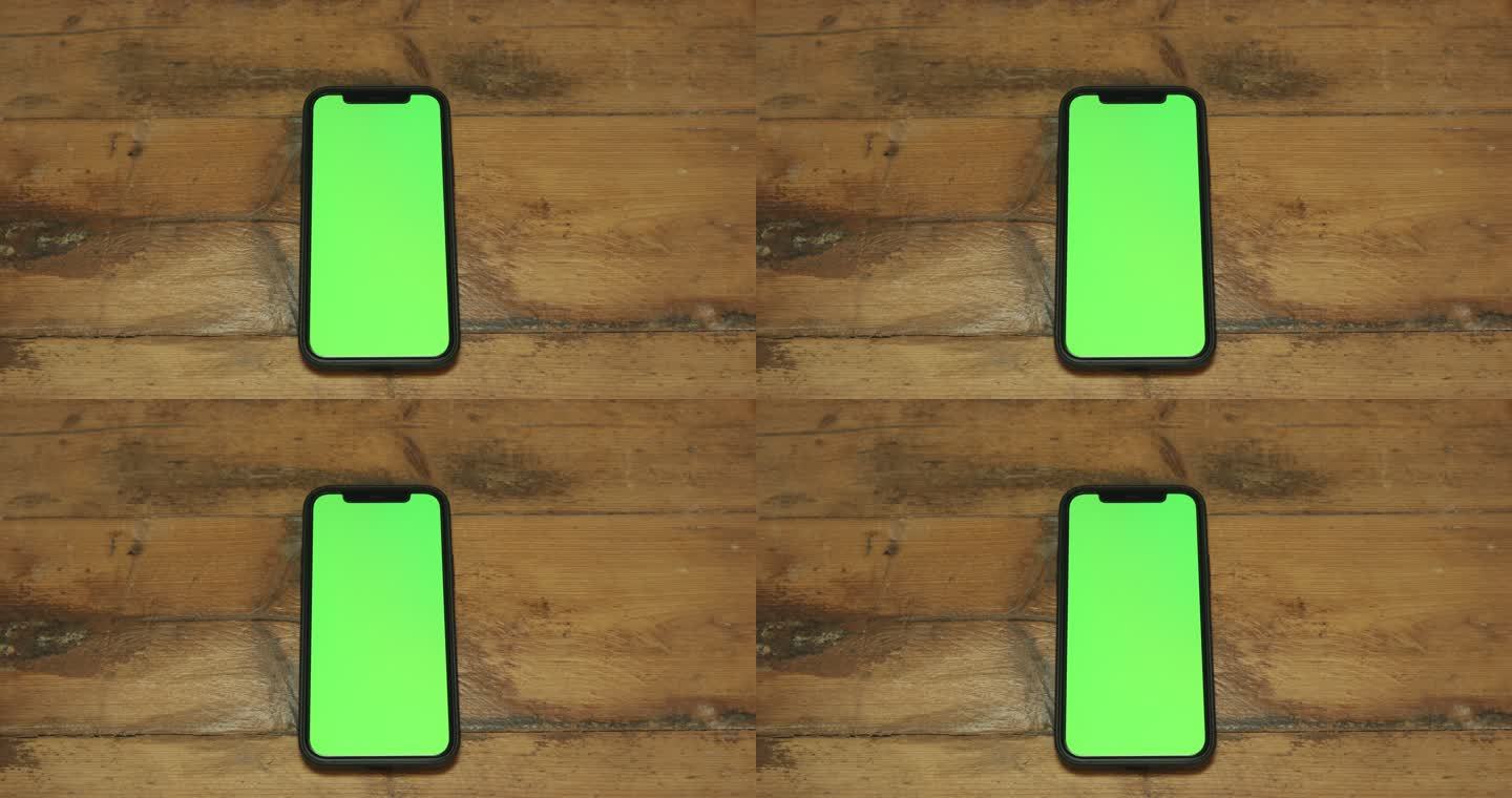 木制桌子上的绿色屏幕电话