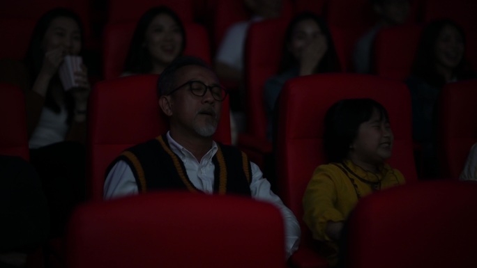 亚洲中国老人在电影院和孙女看电影睡着了
