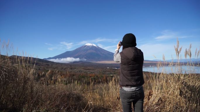美丽的女人在拍福吉山的照片。